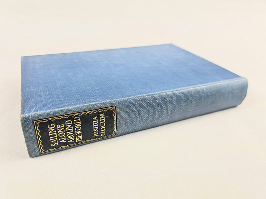 Blue book titled 'Sailing Alone Around the World' by Joshua Slocum on a white background