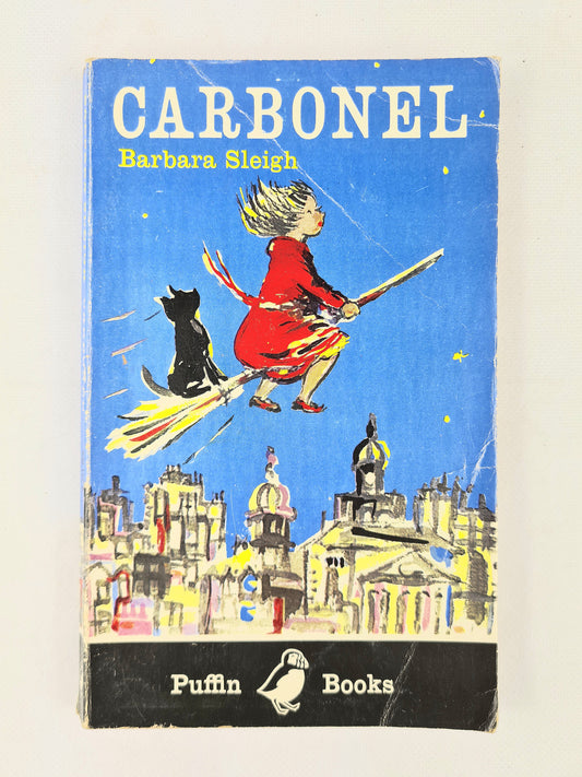 Book cover of 'Carbonel' by Barbara Sleigh featuring a witch and black cat on a broomstick over city buildings.