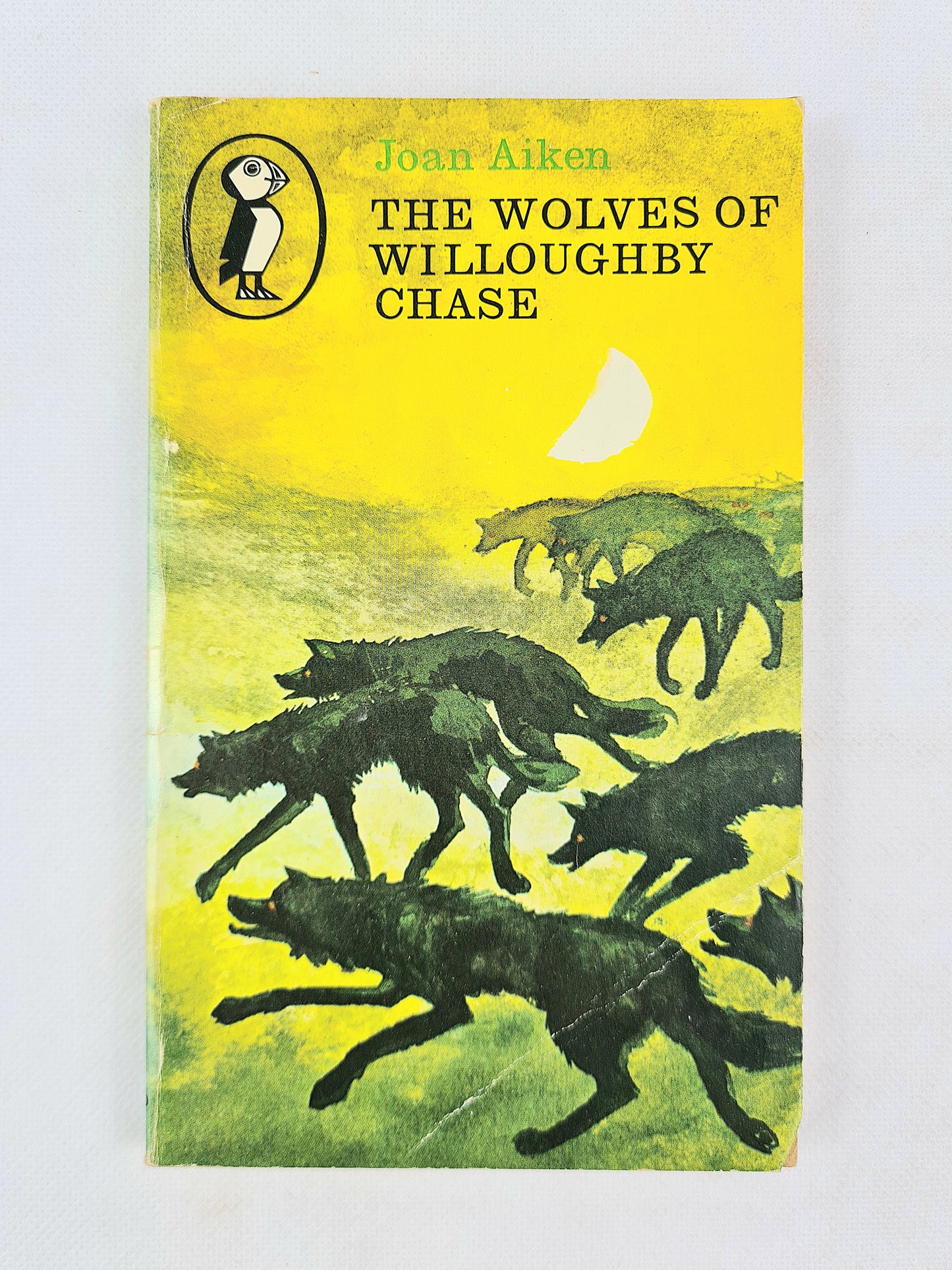 Book cover of 'The Wolves of Willoughby Chase' by Joan Aiken with illustrations of wolves on a white background.