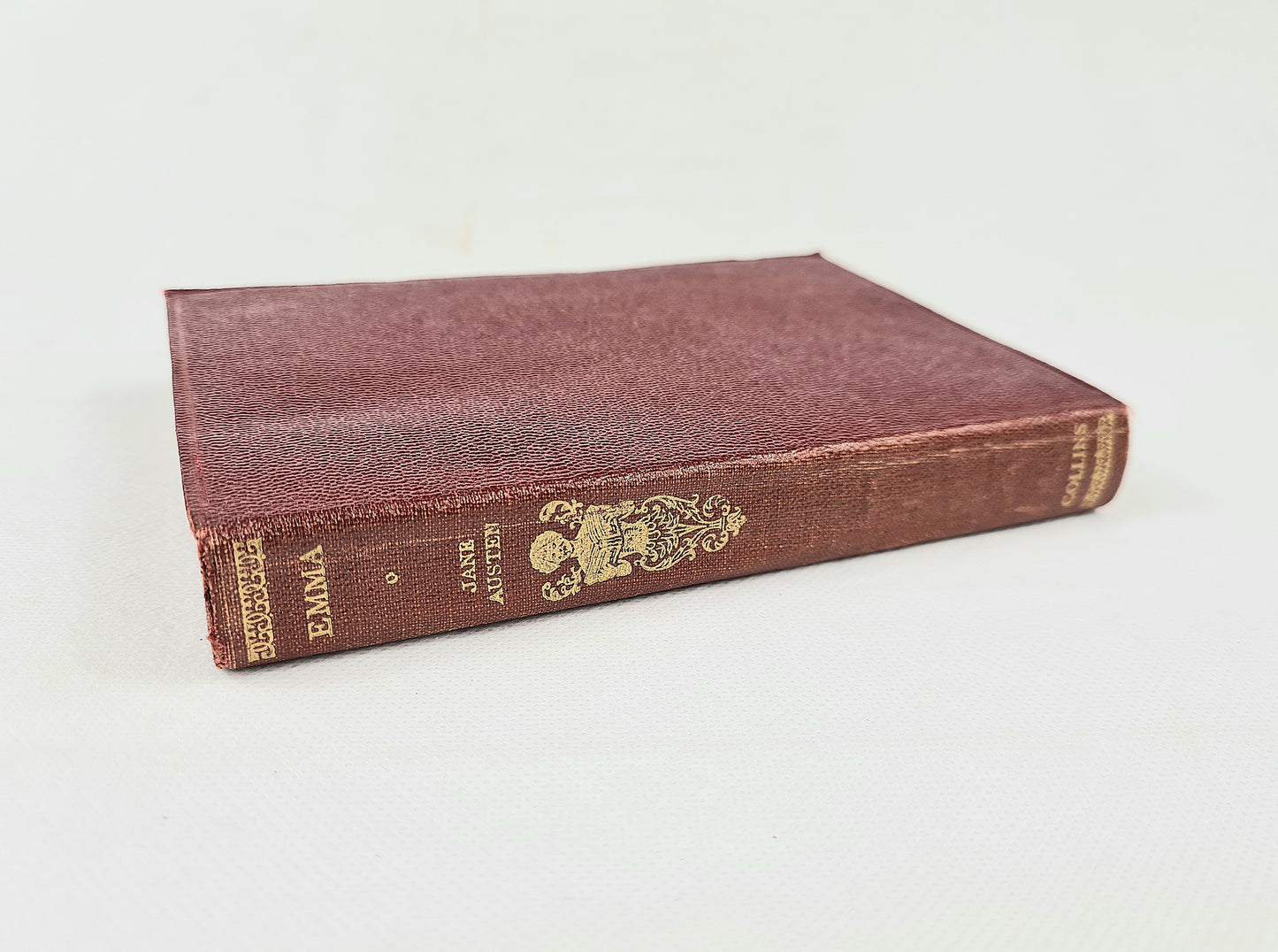 Vintage book titled 'Emma' by Jane Austen on a white background