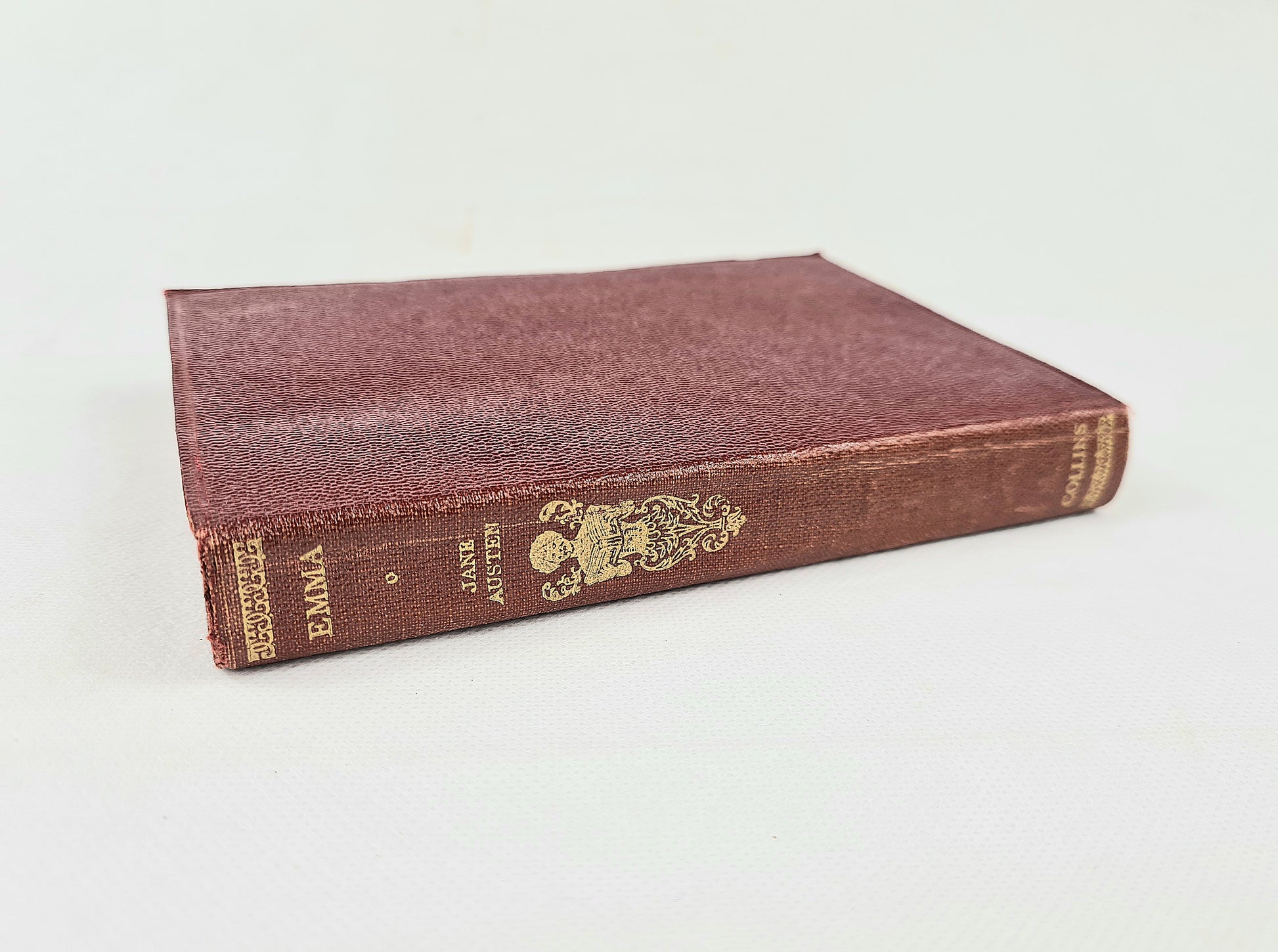 Vintage book titled 'Emma' by Jane Austen on a white background