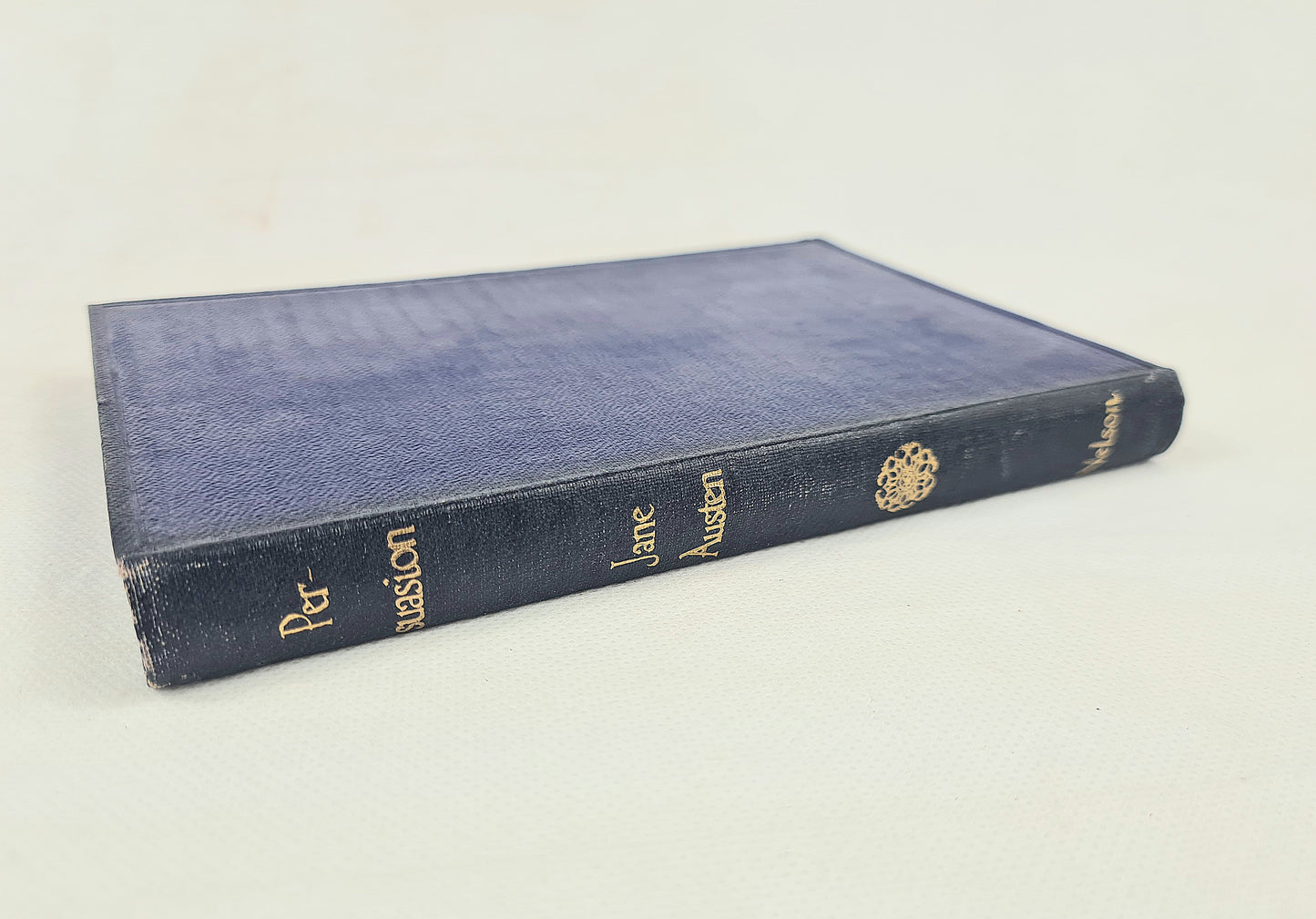A vintage hardcover book with a dark blue textured cover and gold lettering on the spine, photographed on a plain off-white background.