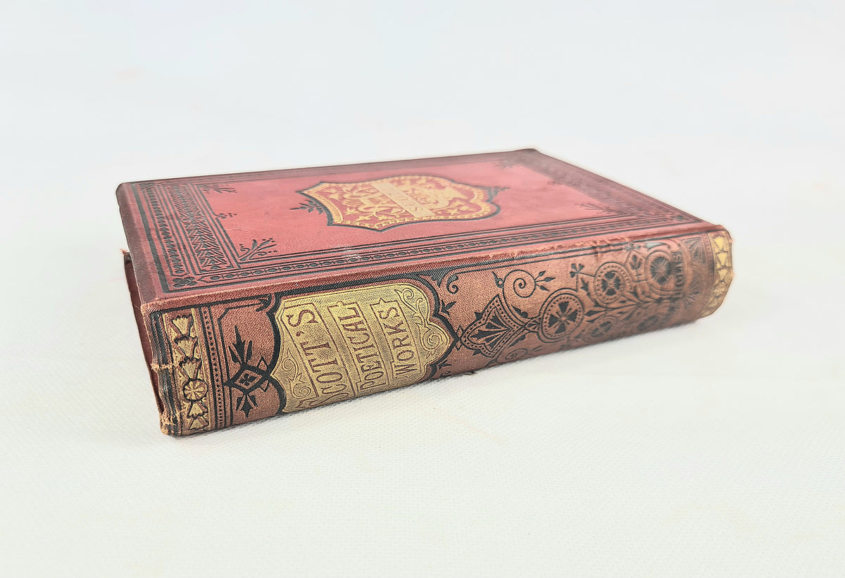 An antique red leather-bound book with gold and black decorative tooling on the spine and cover, photographed on a plain white background.