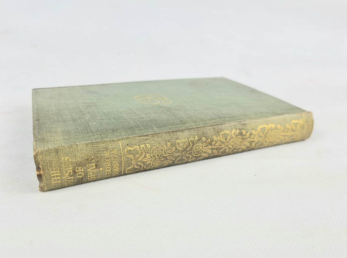 An antique hardcover book with a faded green cloth binding and ornate gold foil detailing on the spine, photographed on a light off-white background.