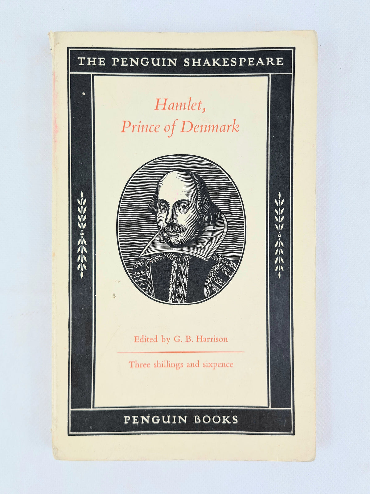Front cover of vintage Penguin Shakespeare paperback Hamlet, Prince of Denmark, showing black border design and woodcut portrait of Shakespeare