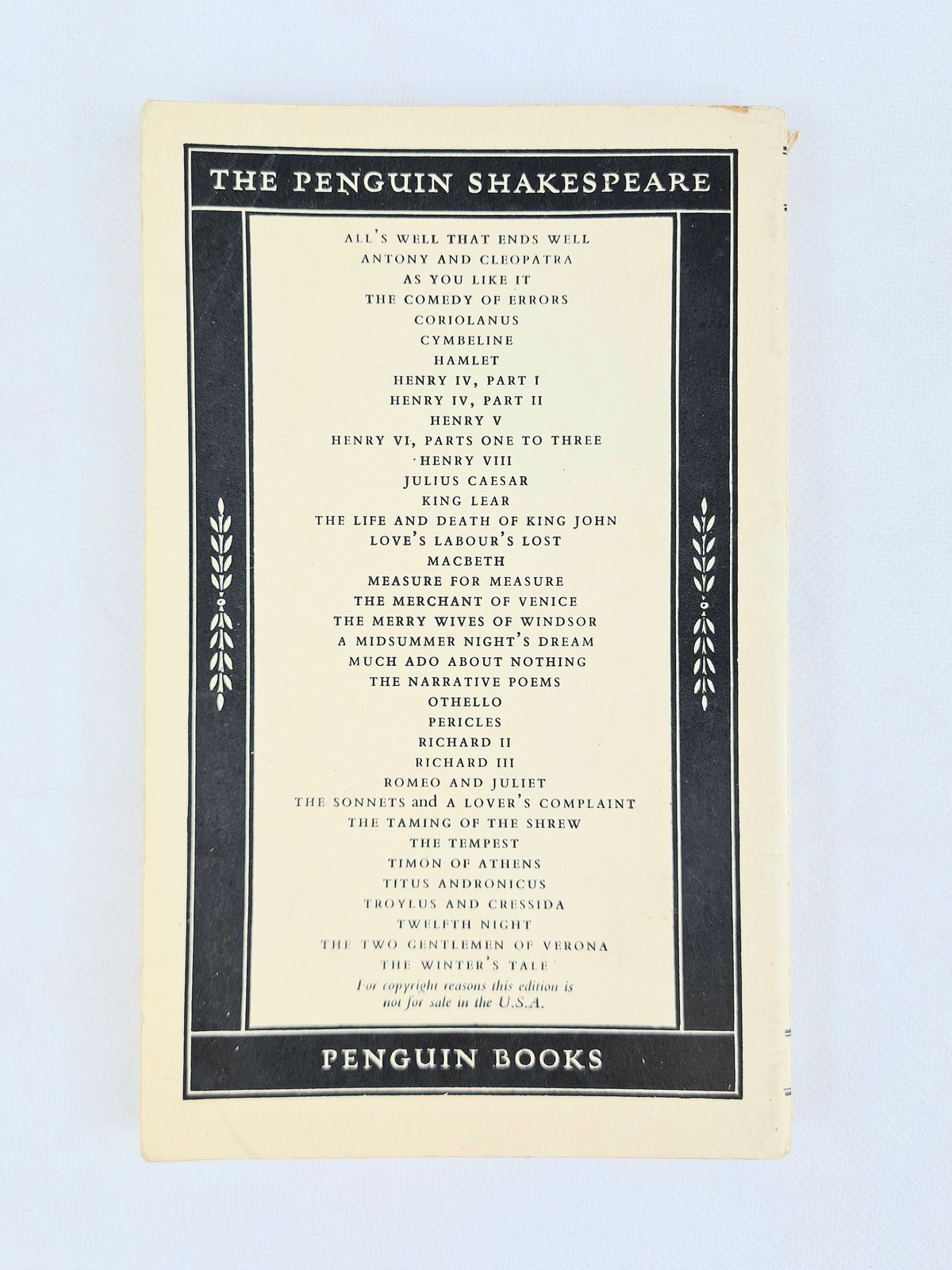 Side spine view of vintage Penguin Shakespeare Hamlet paperback showing spine title text and light edge wear
