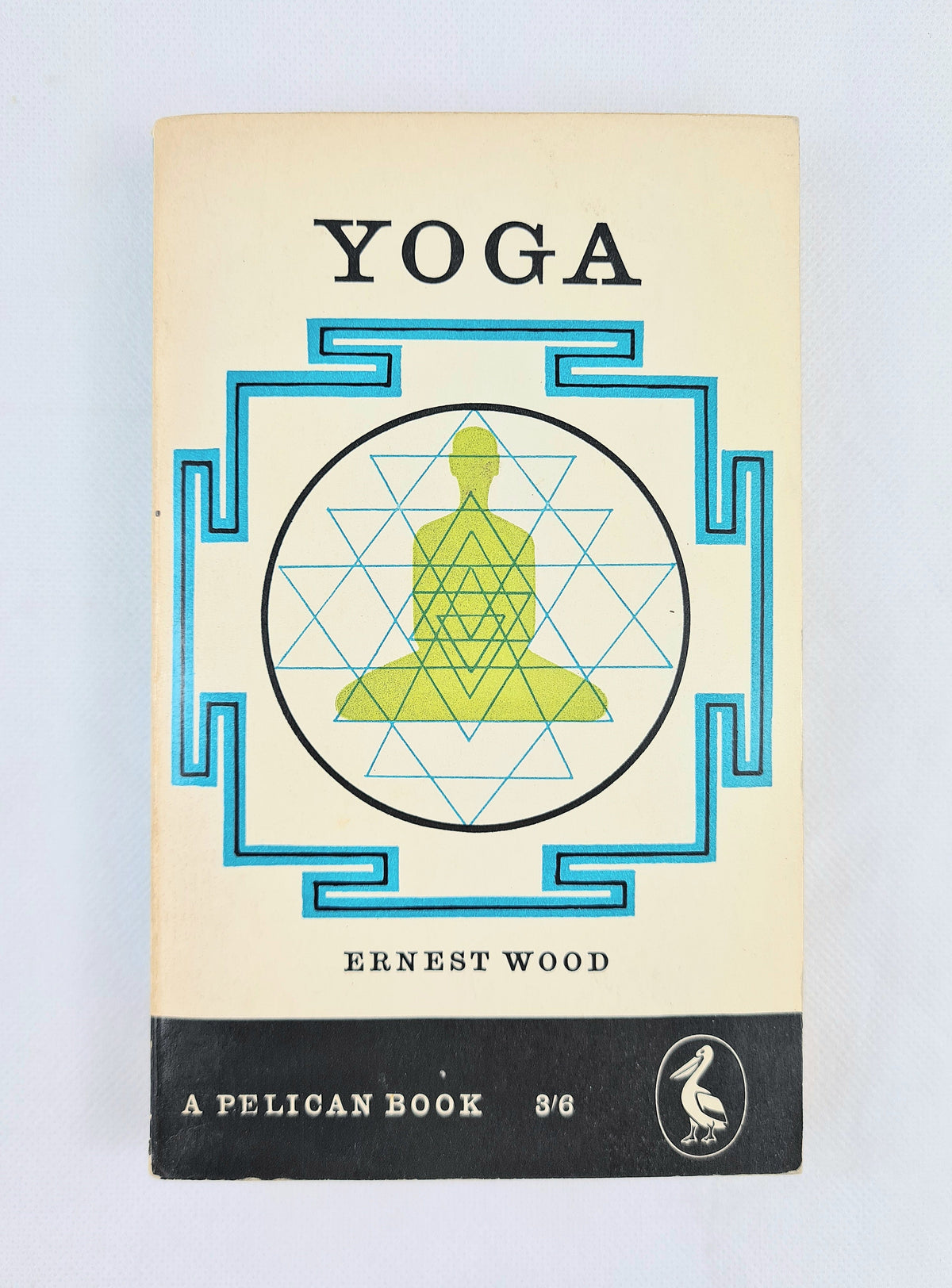 Vintage paperback book cover of 'Yoga' by Ernest Wood, published by Pelican. The cover features a cream-colored background with a black title and a black bottom band.