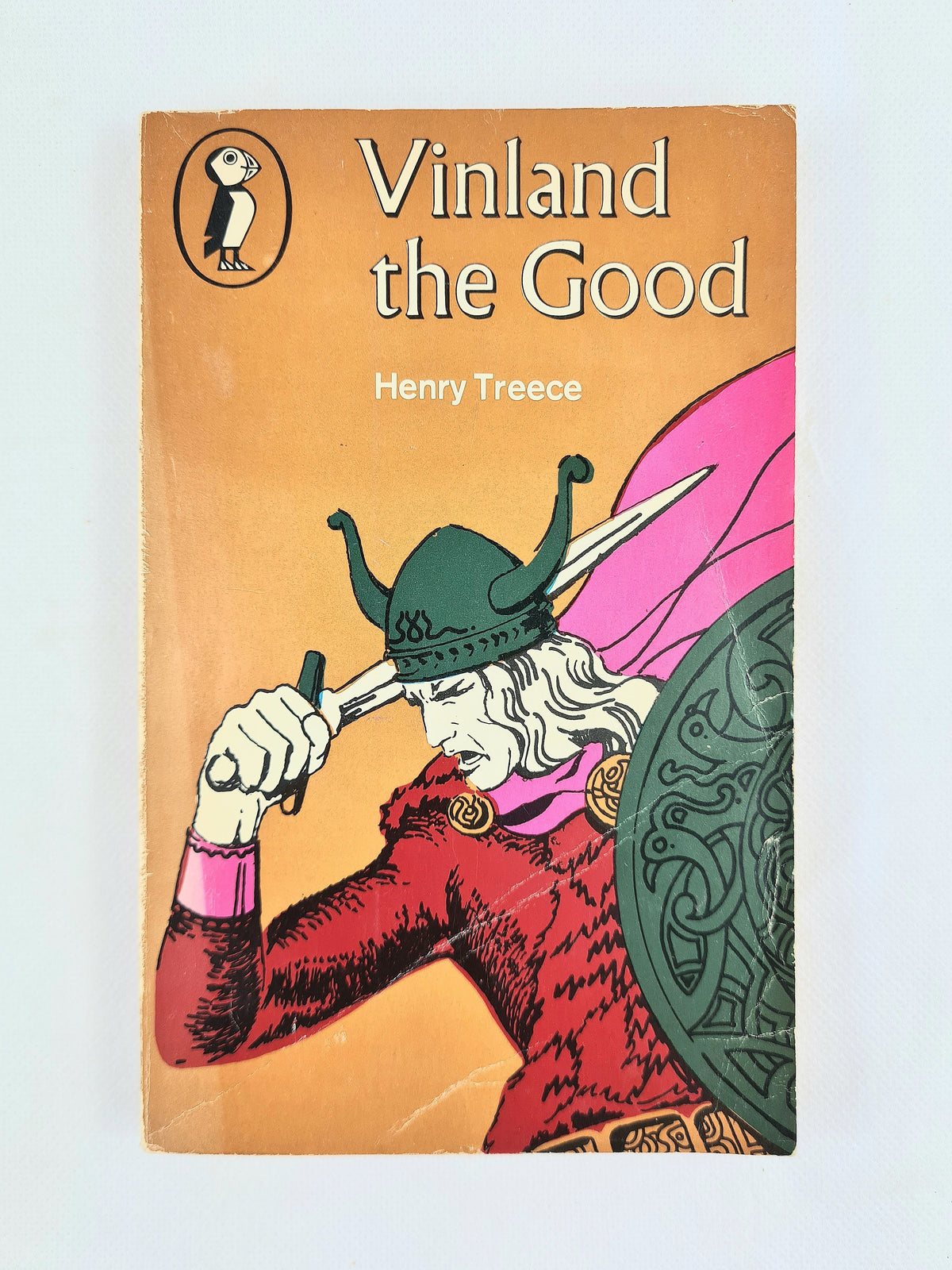 Vintage paperback book of Henry Treece's 'Vinland the Good' featuring a Penguin logo and an illustration of a Viking on a peach-orange cover, set against a plain light background.