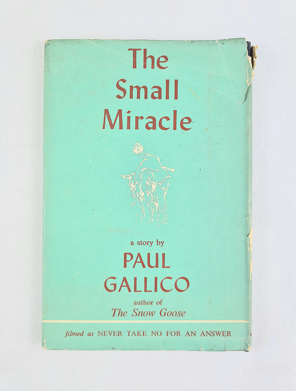 The small miracle by paul gallico. Vintage hardback book on a white background 