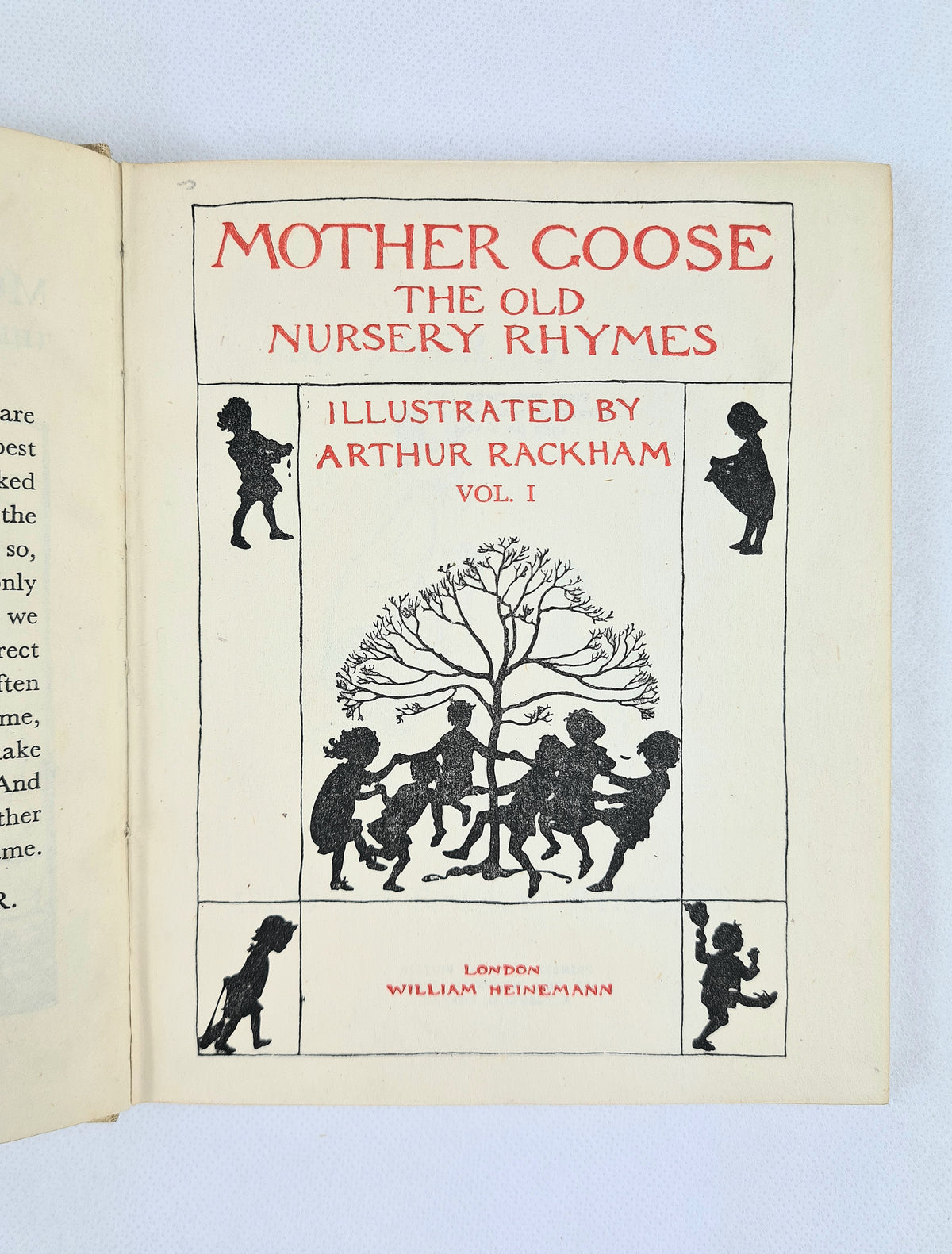 Title page of Mother Goose: The Old Nursery Rhymes Vol. I with red lettering and black silhouettes of children dancing around a tree
